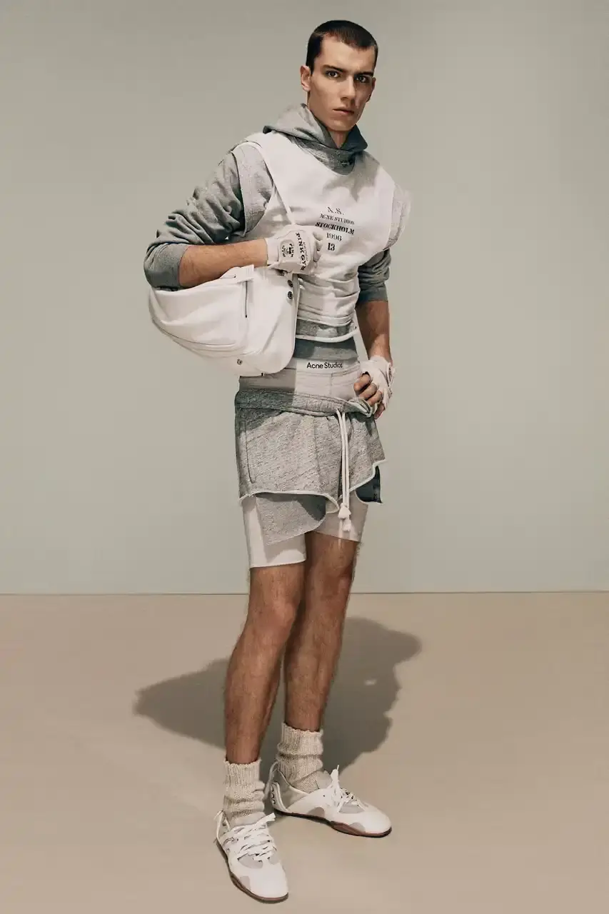 Acne Studios Male model wearing a gray tweed jacket over pink athletic tank top, paired with blue jeans and heart-shaped Acne Studios belt buckle (image 14 of 24)
