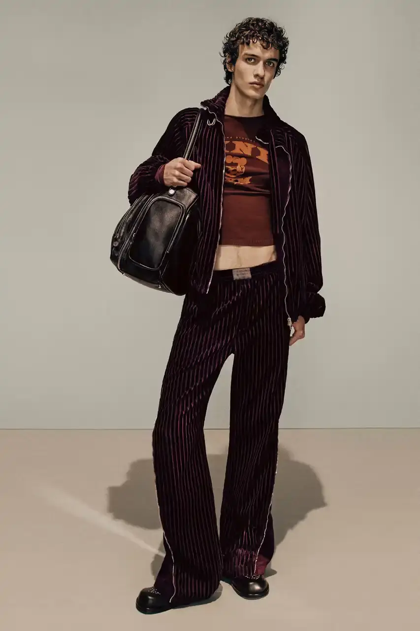 Acne Studios Male model wearing a gray tweed jacket over pink athletic tank top, paired with blue jeans and heart-shaped Acne Studios belt buckle (image 2 of 24)