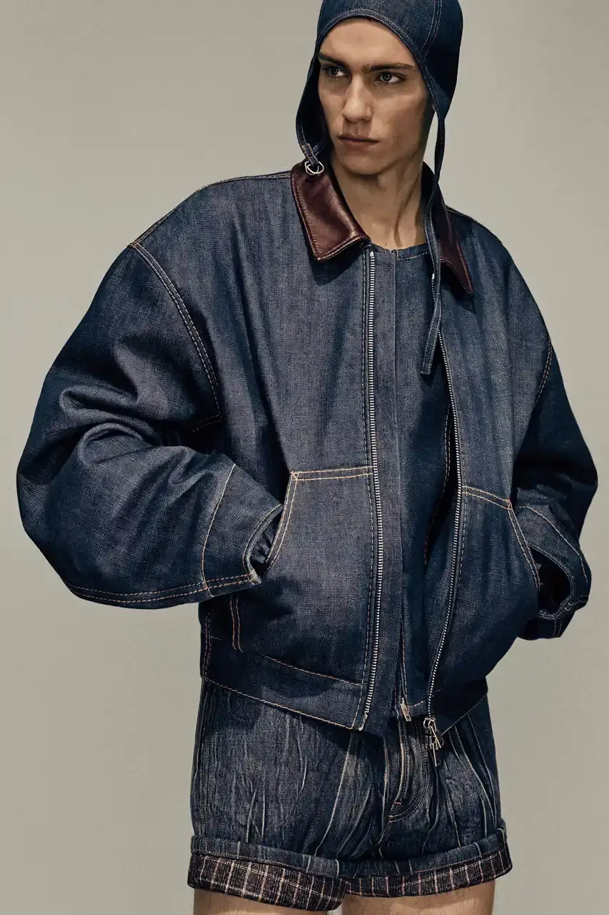 Acne Studios Male model wearing a gray tweed jacket over pink athletic tank top, paired with blue jeans and heart-shaped Acne Studios belt buckle (image 8 of 24)