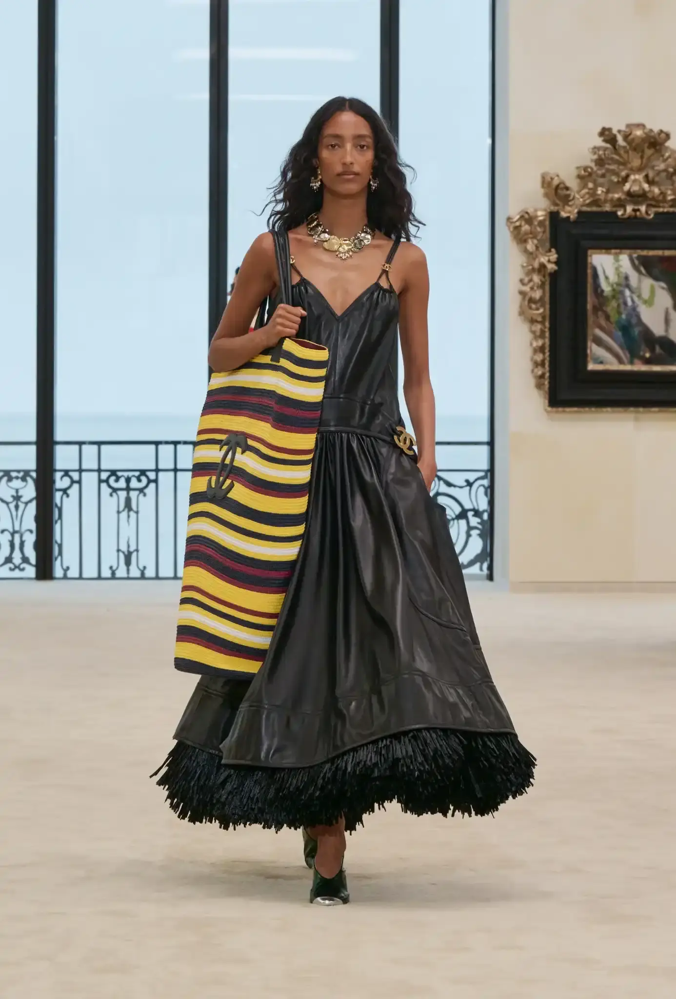 MATTHIEU BLAZY PRESENTS CHANEL CRUISE IN BIARRITZ an image describing the Chanel Cruise collection shown in Biarritz by designer Matthieu Blazy. The article details clothing pieces and front row guests.