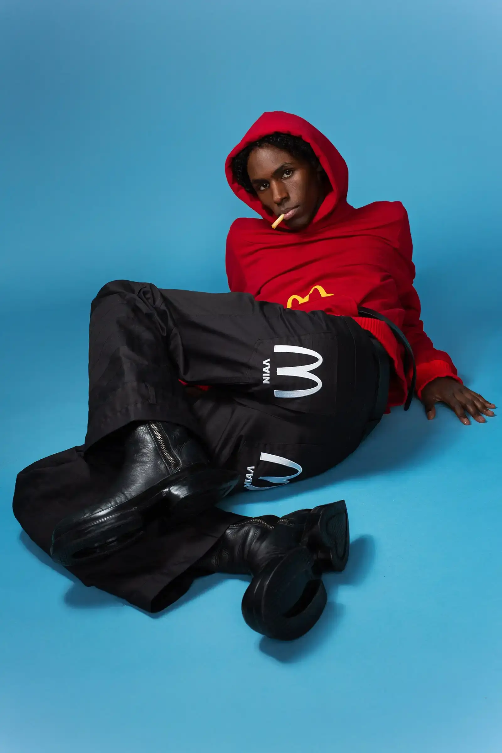 McDonald's/VAIN Models wearing McDonald's-inspired streetwear collection by VAIN, featuring redesigned uniforms in red, yellow, and black colors on a runway. (image 2 of 8)
