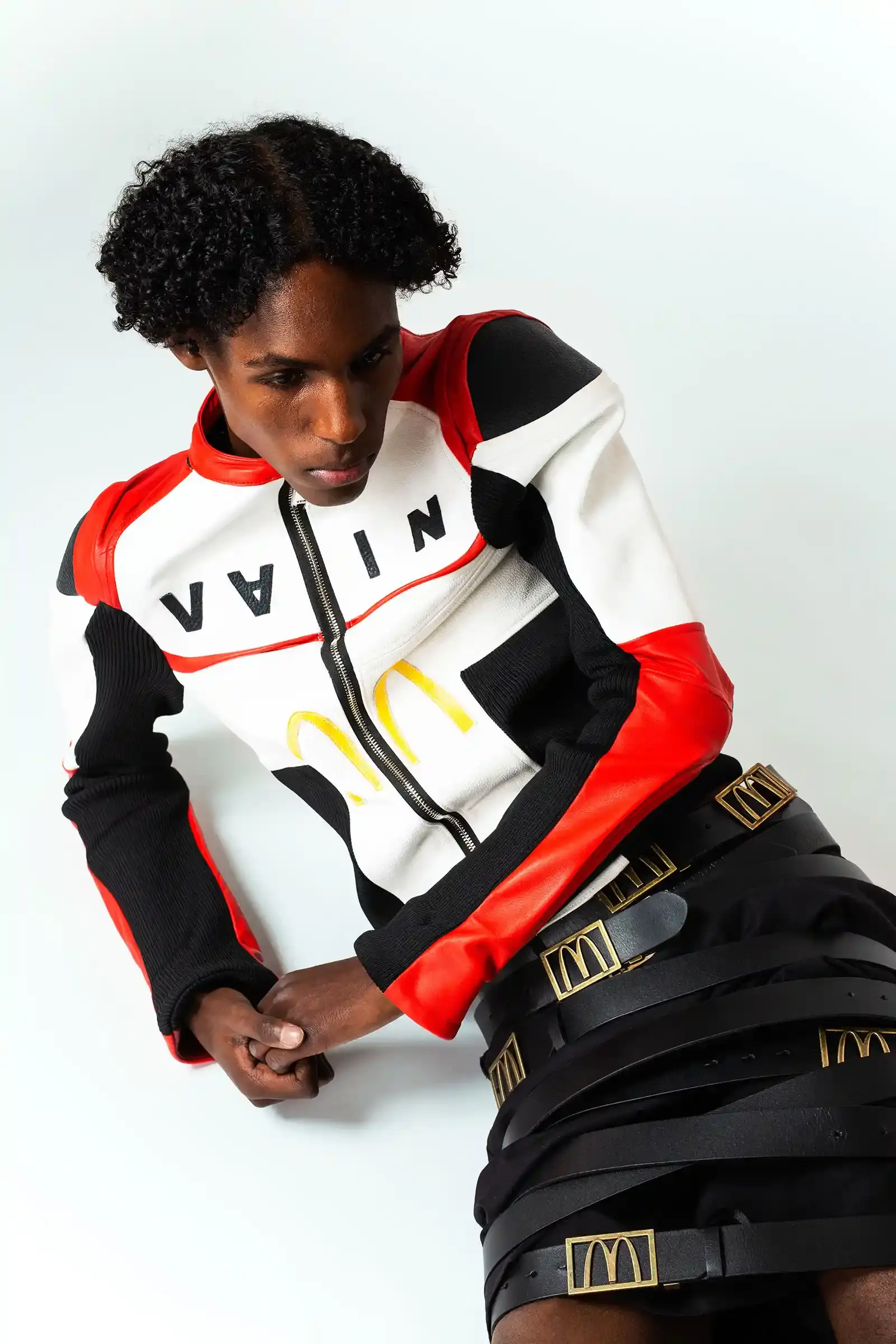 McDonald's/VAIN Models wearing McDonald's-inspired streetwear collection by VAIN, featuring redesigned uniforms in red, yellow, and black colors on a runway. (image 3 of 8)