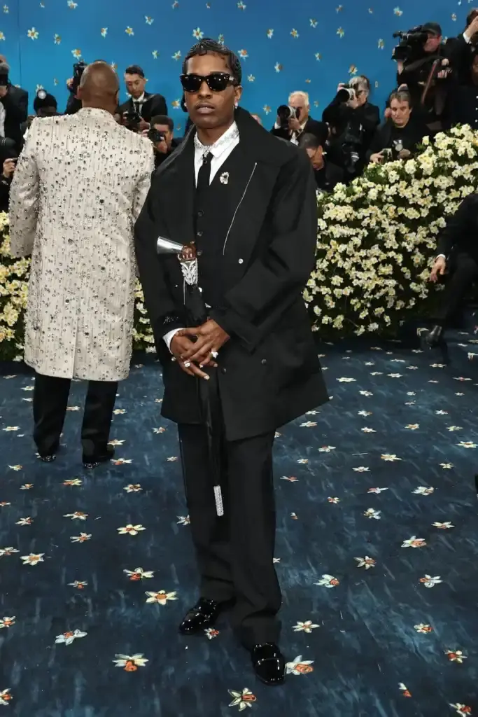 MET GALA 2025: FASHION'S ELITE INTERPRET "TAILORED FOR YOU" image of the 2025 Met Gala event celebrating the "Superfine: Tailoring Black Style" exhibition. It describes key celebrity appearances including André 3000's piano-shouldered look, pregnant Rihanna, and Teyana Taylor's Ruth E. Carter design. The article mentions prominent attendees like A$AP Rocky, Lewis Hamilton, and Zendaya, and highlights Moncler's first-time participation with custom designs for celebrities including Serena Williams and Alicia Keys. The text explains how the event's "Tailored for You" theme connected to Black dandyism and cultural identity expressed through fashion. (image 5 of 10)
