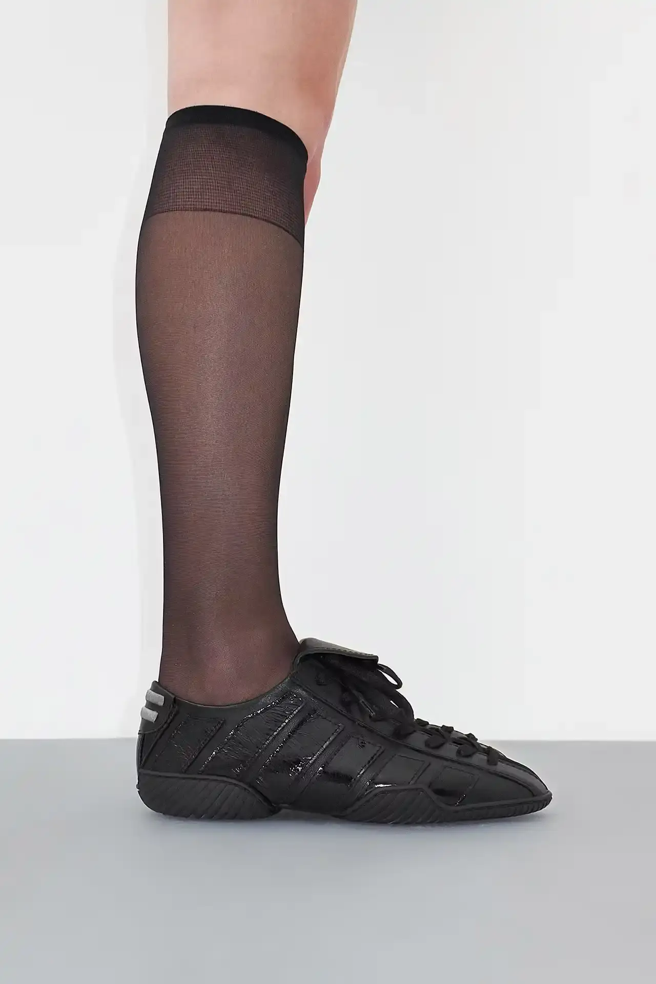 MIISTA'S NIKOLETTA: A THROWBACK TO 80S ATHLETIC FOOTWEAR Photo about Miista's new Nikoletta sneaker. Describes the low-profile design inspired by 1980s athletic footwear, construction details including goat leather and fold-over tongue, available colors (black, brown/navy, black/white), price ($415), and where to purchase. Includes quote from creative director Laura Villasenin about the brand's philosophy of continuous improvement and craftsmanship. (image 3 of 4)