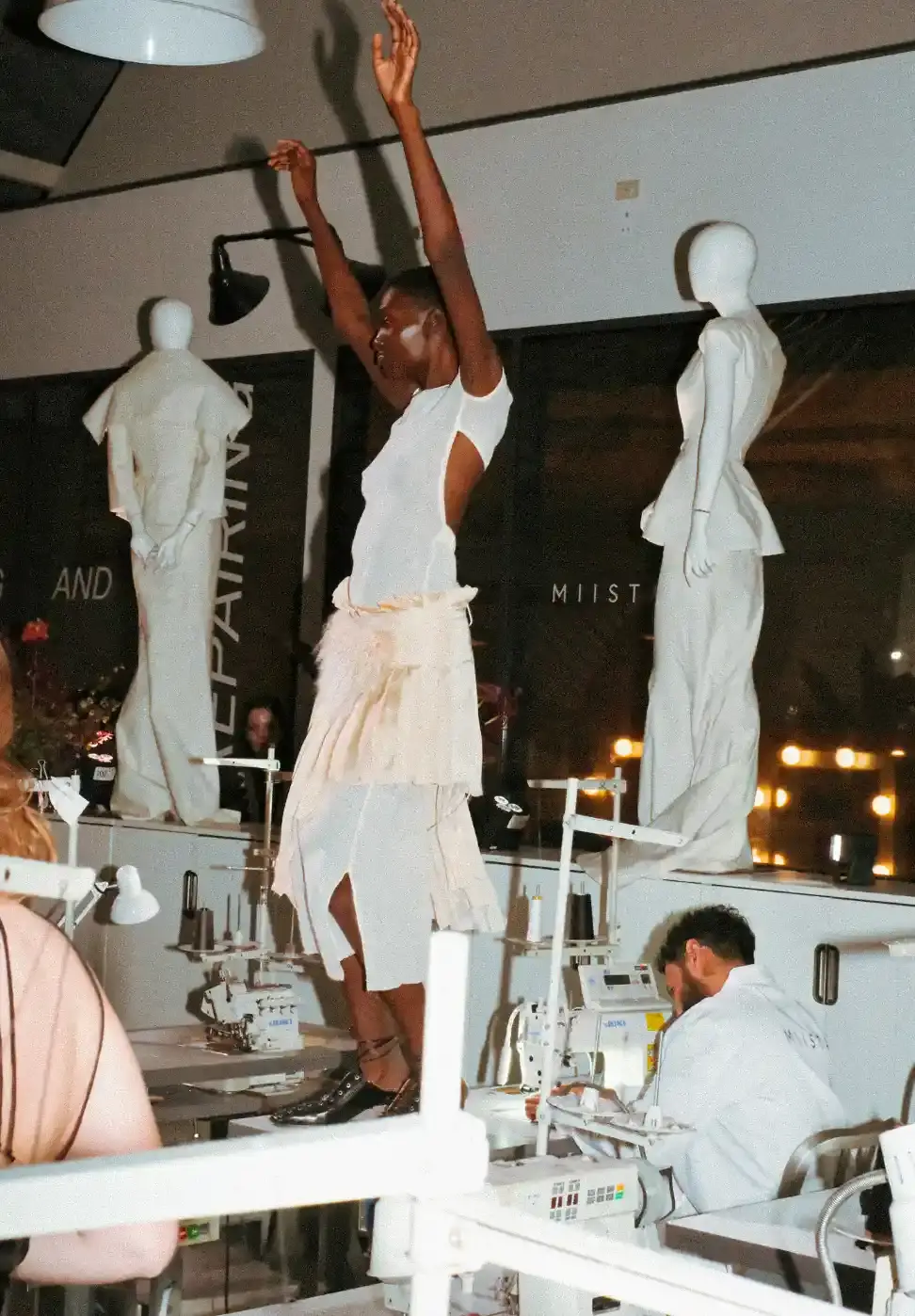 MIISTA SS26 COMBINES TECHNO MUSIC AND GARMENT MENDING An image about on the Miista Spring/Summer 2026 launch in Los Angeles. The text details the music performances and the live garment mending station at The Evans Group factory. (image 6 of 10)