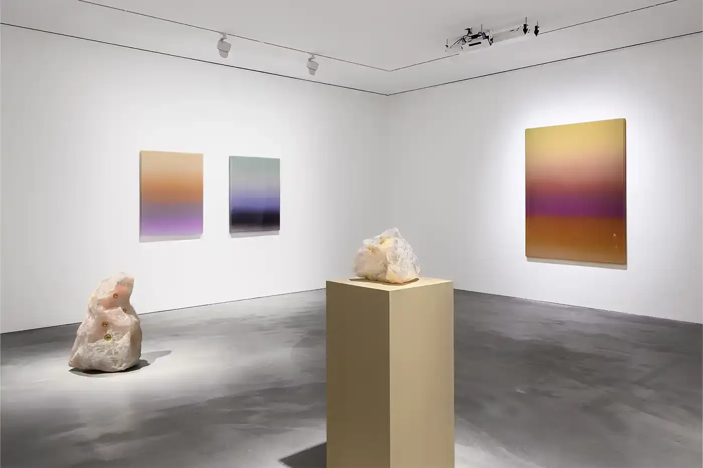 Courtesy Of The Artist and Pace Hong Kong A gallery installation view featuring Mika Tajima's multidisciplinary artwork. Translucent acrylic paintings with gradient pigments, textile spectrograms of brain wave data, and rose quartz and glass sculptures that investigate technological mediation of human experience.