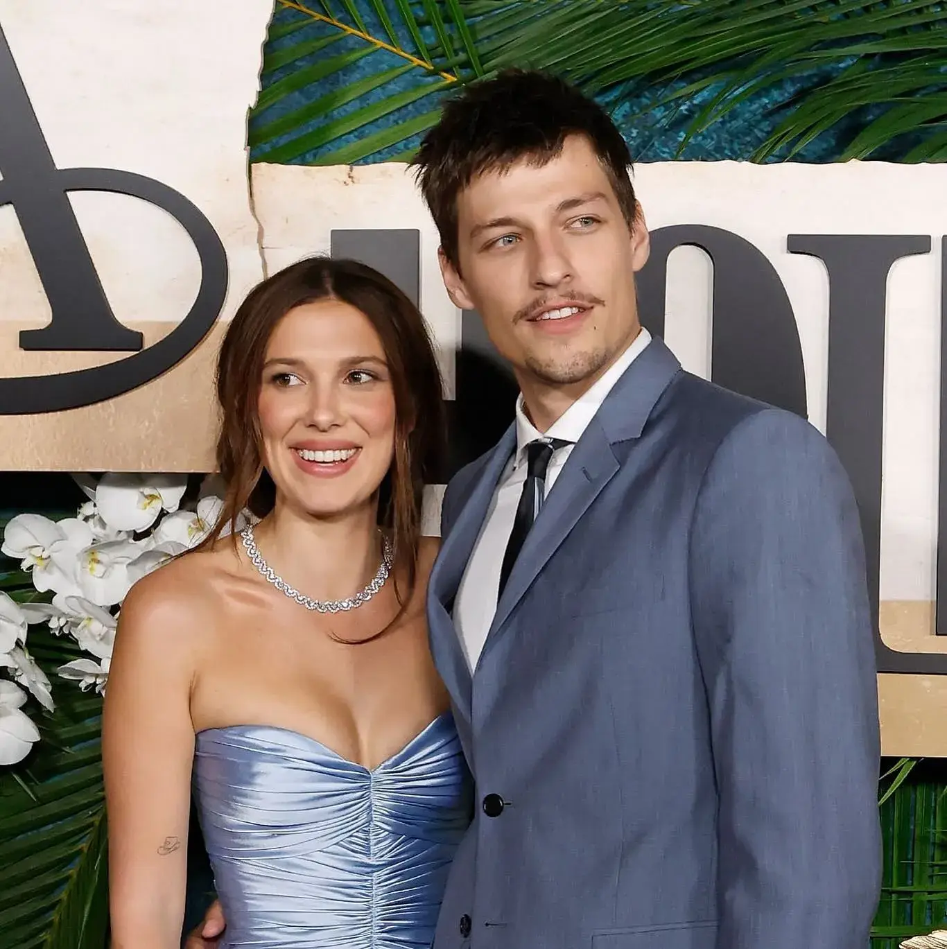 A close view of Millie Bobby Brown and Jake Bongiovi holding the hand of their newly adopted baby.