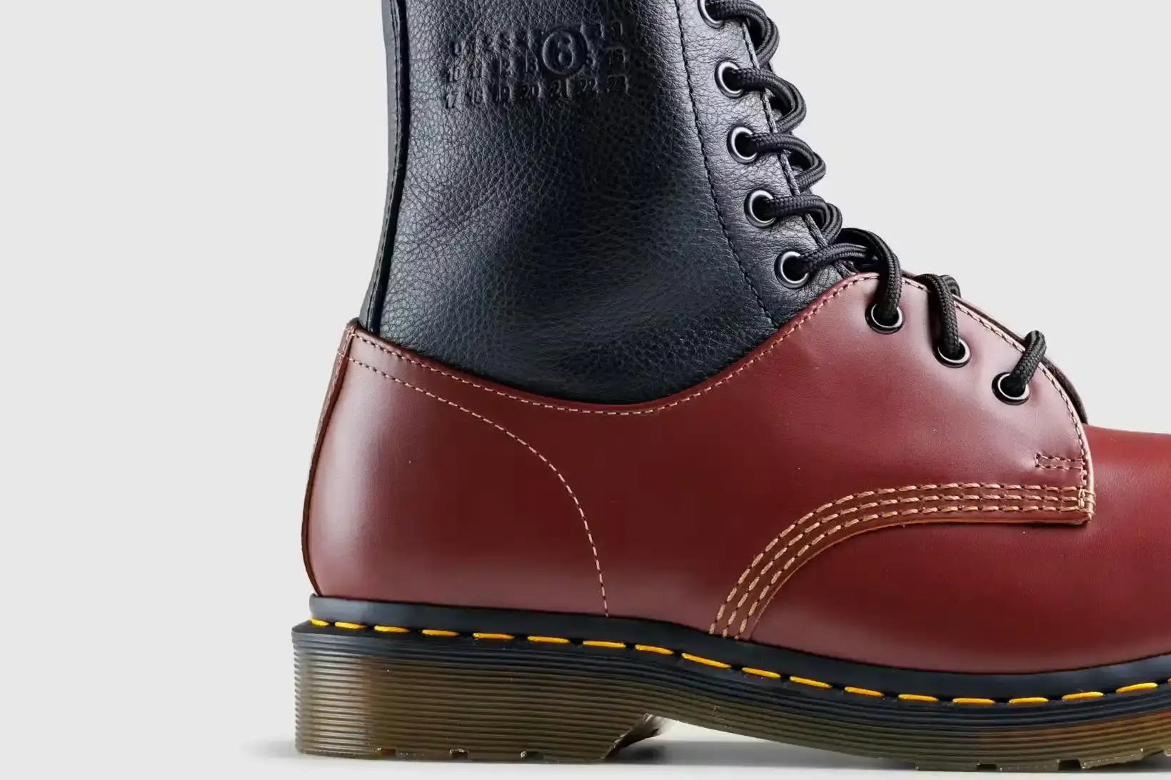Black and red hybrid boot combining Dr. Martens 1460 and 1461 styles, featuring signature yellow stitching and chunky sole
