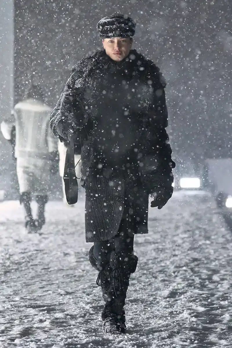 Moncler Moncler's Fall/Winter 2025 Grenoble collection showcase held at Courchevel Altiport in the French Alps. It details how the runway show transformed Europe's highest airport into a fashion venue at 2,008 meters above sea level. The article outlines the collection's 140 looks that blend urban style with mountain functionality, featuring innovative materials like denim and canvas alongside traditional winter textiles. It mentions the craftsmanship details including embroidery and intarsia patterns on ski suits. The article also notes celebrity attendees and a special snowboard collaboration with Shaun White's WHITESPACE brand. The content is organized in paragraphs describing the event setting, collection details, and notable highlights (image 2 of 22)