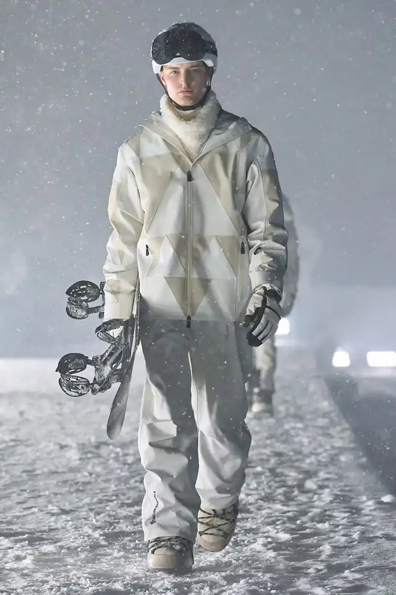 Moncler Moncler's Fall/Winter 2025 Grenoble collection showcase held at Courchevel Altiport in the French Alps. It details how the runway show transformed Europe's highest airport into a fashion venue at 2,008 meters above sea level. The article outlines the collection's 140 looks that blend urban style with mountain functionality, featuring innovative materials like denim and canvas alongside traditional winter textiles. It mentions the craftsmanship details including embroidery and intarsia patterns on ski suits. The article also notes celebrity attendees and a special snowboard collaboration with Shaun White's WHITESPACE brand. The content is organized in paragraphs describing the event setting, collection details, and notable highlights