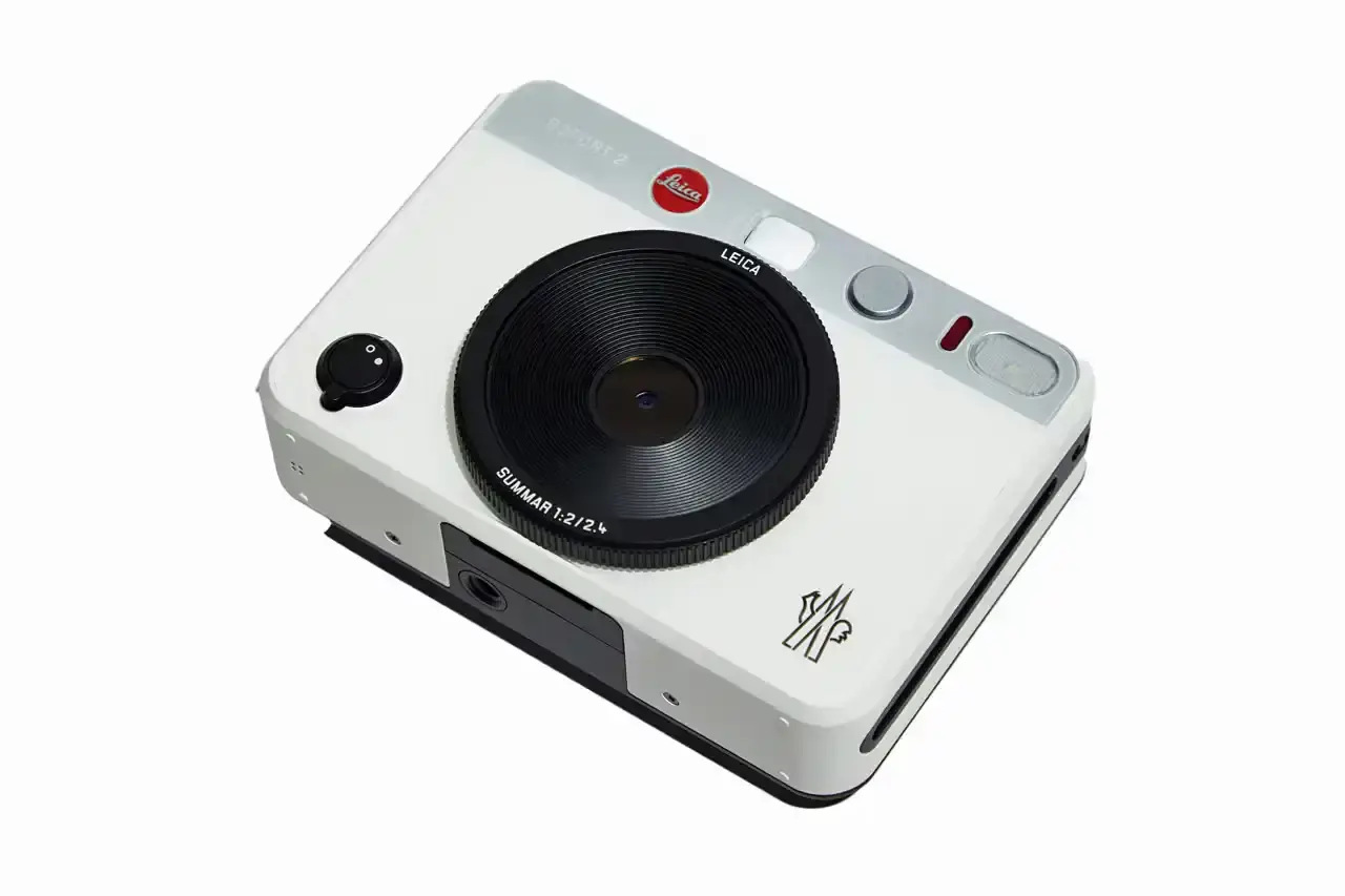 Moncler Limited edition white Leica camera featuring Moncler logo on front and FW25 Courchevel runway inscription on top, created exclusively for Moncler Grenoble's alpine fashion show guests.