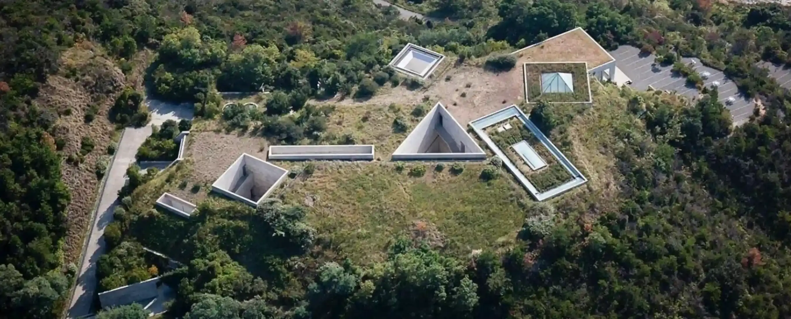 Aerial view of the Chichu Art Museum, with geometric skylights emerging from green hills