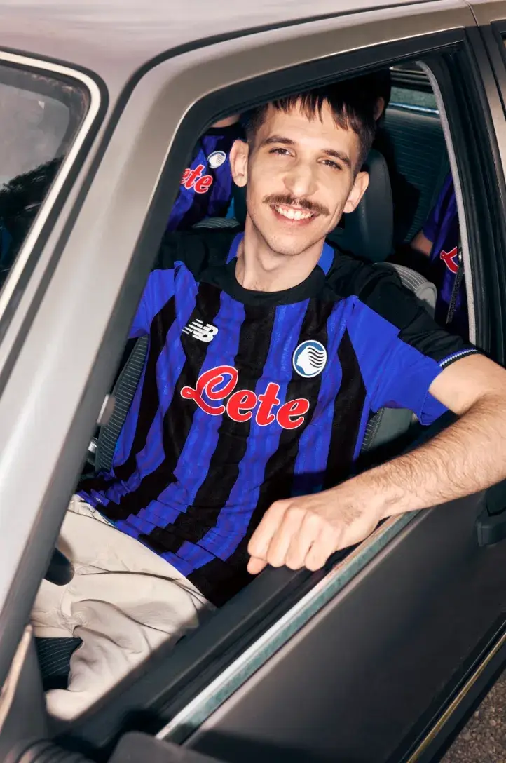 NEW BALANCE REVEALS ATALANTA BC 2026/27 KIT An image of the new Atalanta BC home jersey for the 2026/27 season, featuring Oasis Blue and black vertical stripes with metallic accents. (image 4 of 4)