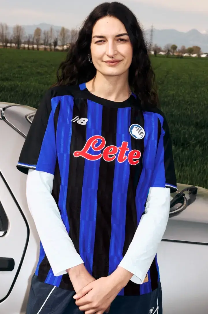NEW BALANCE REVEALS ATALANTA BC 2026/27 KIT An image of the new Atalanta BC home jersey for the 2026/27 season, featuring Oasis Blue and black vertical stripes with metallic accents.