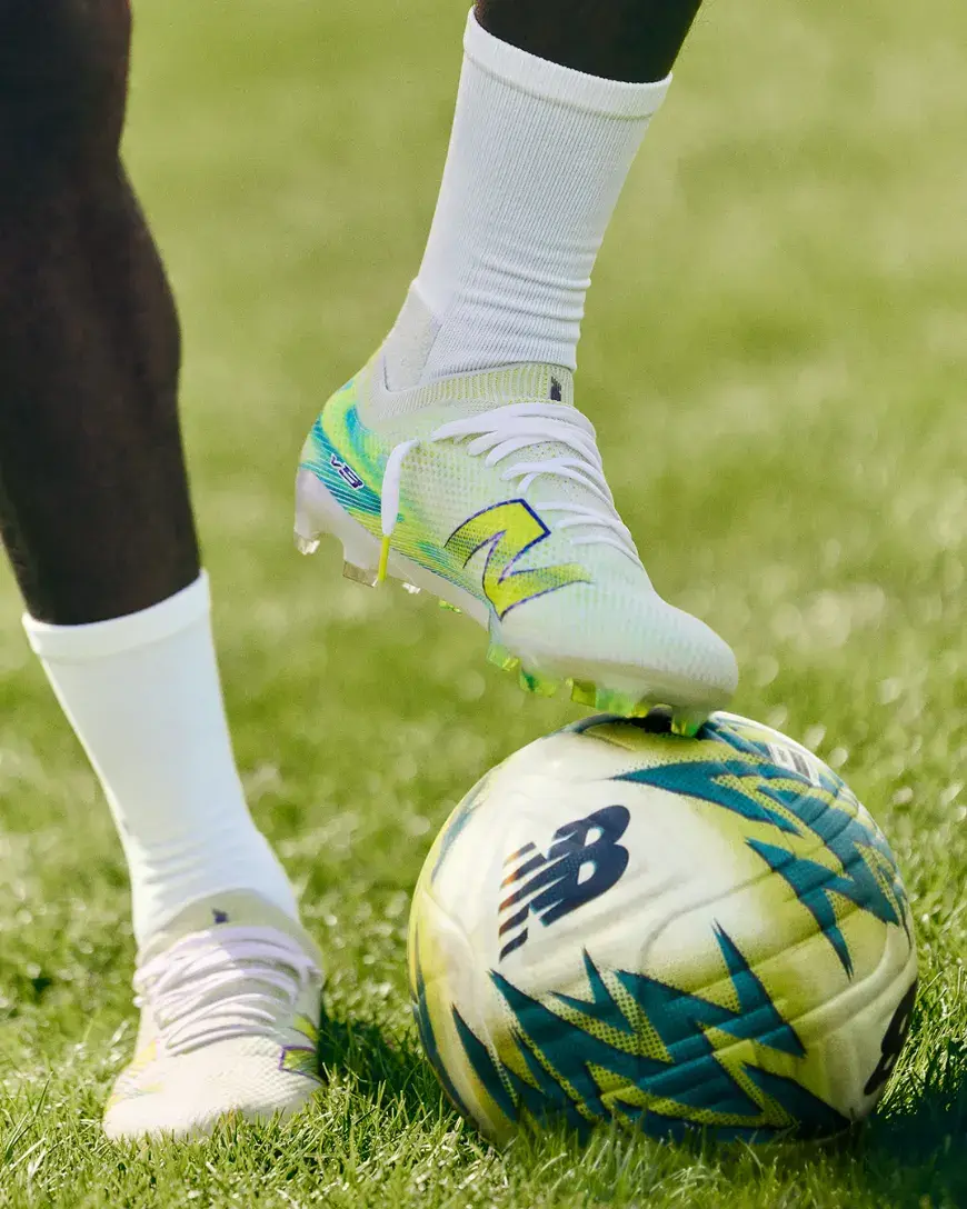 NEW BALANCE LAUNCHES FURON V9 FOOTBALL BOOTS Image of the new alkaline green and metallic blue New Balance Furon v9 football boots showing the soleplate and upper design.