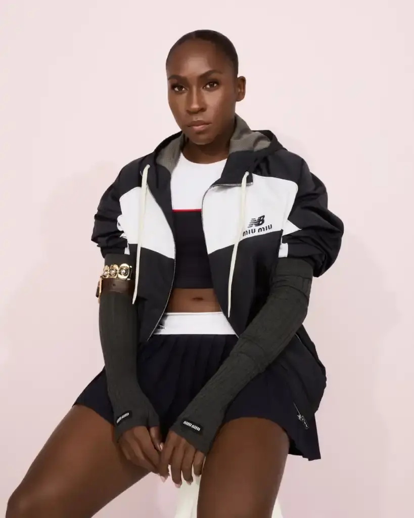 COCO GAUFF TO SPORT NEW BALANCE AND MIU MIU TENNIS COLLECTION image of collaboration between New Balance and Miu Miu featuring tennis champion Coco Gauff. It details how Gauff will wear the collection during tournaments in Rome, Berlin, and Cincinnati, describes the on-court outfits with color-block designs and co-branded Coco CG2 shoes, as well as off-court attire including zip hoodies and 530 SL sneakers. The collection launches September 10th at select stores and online, with Gauff hosting a Miu Miu Select event in New York the same day to showcase her personal picks from the Fall/Winter 2025 collection. (image 5 of 6)