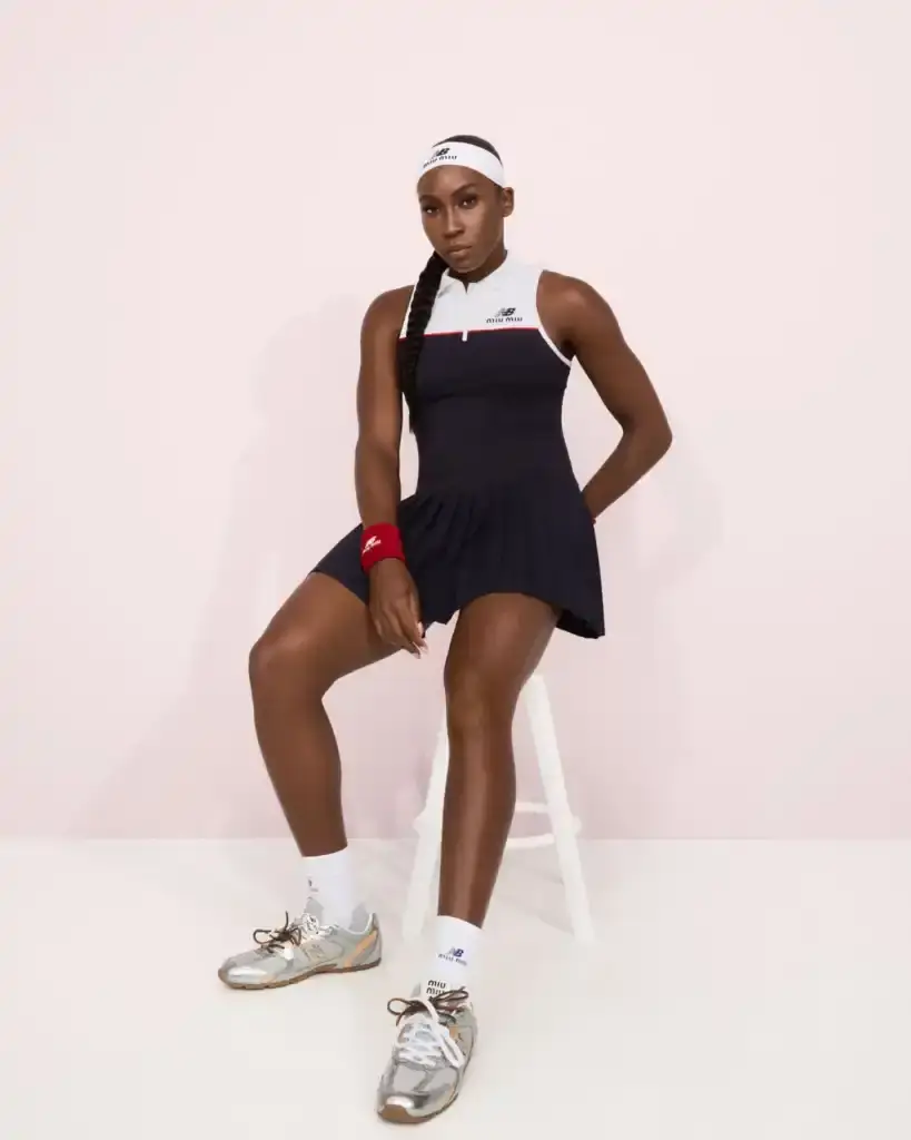 COCO GAUFF TO SPORT NEW BALANCE AND MIU MIU TENNIS COLLECTION image of collaboration between New Balance and Miu Miu featuring tennis champion Coco Gauff. It details how Gauff will wear the collection during tournaments in Rome, Berlin, and Cincinnati, describes the on-court outfits with color-block designs and co-branded Coco CG2 shoes, as well as off-court attire including zip hoodies and 530 SL sneakers. The collection launches September 10th at select stores and online, with Gauff hosting a Miu Miu Select event in New York the same day to showcase her personal picks from the Fall/Winter 2025 collection. (image 4 of 6)