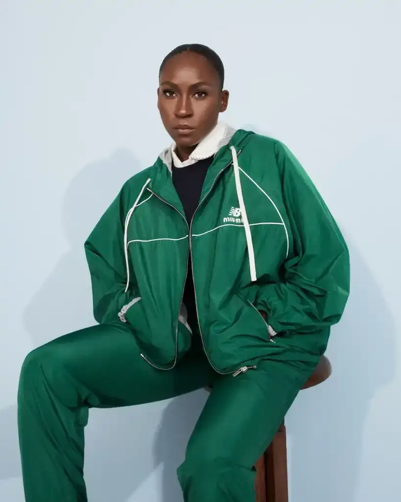 COCO GAUFF TO SPORT NEW BALANCE AND MIU MIU TENNIS COLLECTION image of collaboration between New Balance and Miu Miu featuring tennis champion Coco Gauff. It details how Gauff will wear the collection during tournaments in Rome, Berlin, and Cincinnati, describes the on-court outfits with color-block designs and co-branded Coco CG2 shoes, as well as off-court attire including zip hoodies and 530 SL sneakers. The collection launches September 10th at select stores and online, with Gauff hosting a Miu Miu Select event in New York the same day to showcase her personal picks from the Fall/Winter 2025 collection. (image 2 of 6)