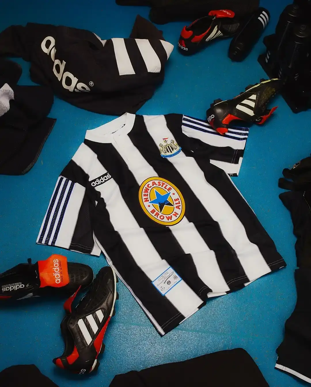 Adidas Newcastle United 1995-96 home shirt remake featuring black and white stripes, Henley collar, adidas trefoil logo, and Newcastle Brown Ale sponsor