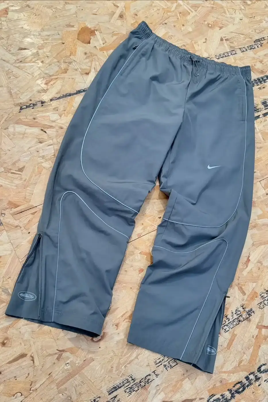 Nike x Corteiz apparel collection featuring football-inspired windbreakers, trousers, and polo shirts with co-branded designs in athletic streetwear style. (image 4 of 5)