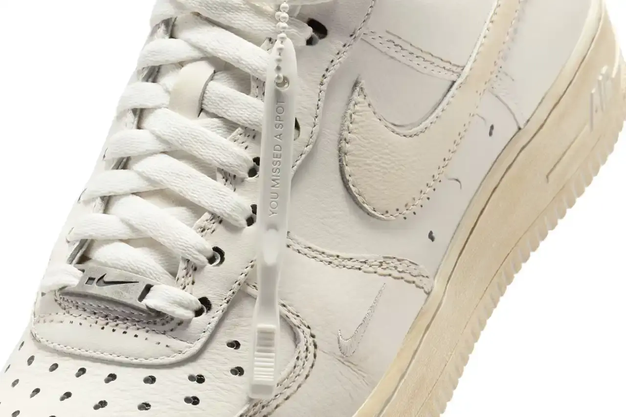 NIKE'S UNIQUE TWIST: "DIRTY" AIR FORCE 1 LOW SNEAKERS REVEALED image of details Nike's upcoming "Dirty Triple White" Air Force 1 Low sneakers, which feature an innovative design that appears worn when new but becomes cleaner with use. The article covers the release through Nike's .SWOOSH platform, mentions the included toothbrush for cleaning, and notes the May 7 US-only release date via the SNKRS app. The piece provides context about Nike's previous digital-physical crossover releases and explains the concept behind this unconventional approach to the classic silhouette. (image 6 of 8)