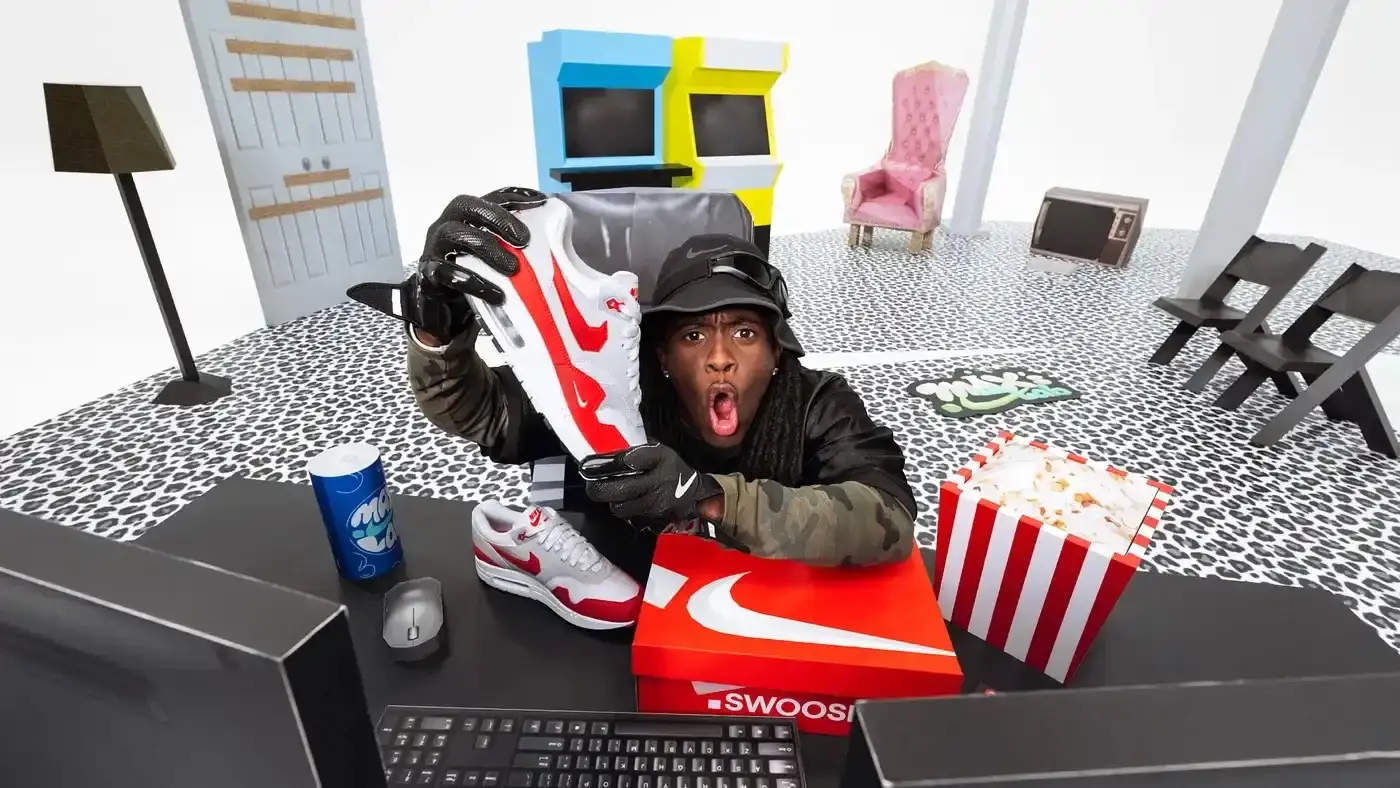 Kai Cenat unboxing the Nike Air Max 1 Low Poly in an arcade-themed setting, showcasing the shoe's pixelated details.