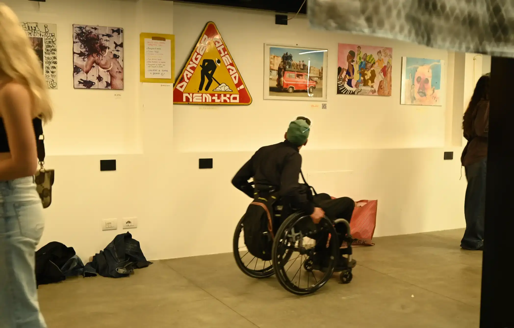 NO BALL GAMES: MILAN'S GRASSROOTS ART MOVEMENT TAKES SHAPE image of the No Ball Games art movement in Milan, founded by photographer Enrico Rassu in 2024. It describes the movement's horizontal hierarchy, philosophy of unrestricted expression, and signature event "70 Chiodi" which allowed hundreds of artists to display work without curation. The piece includes background on Rassu's career as a photographer for musicians and brands, and details how the movement aims to break down barriers in the traditional art world. (image 10 of 13)