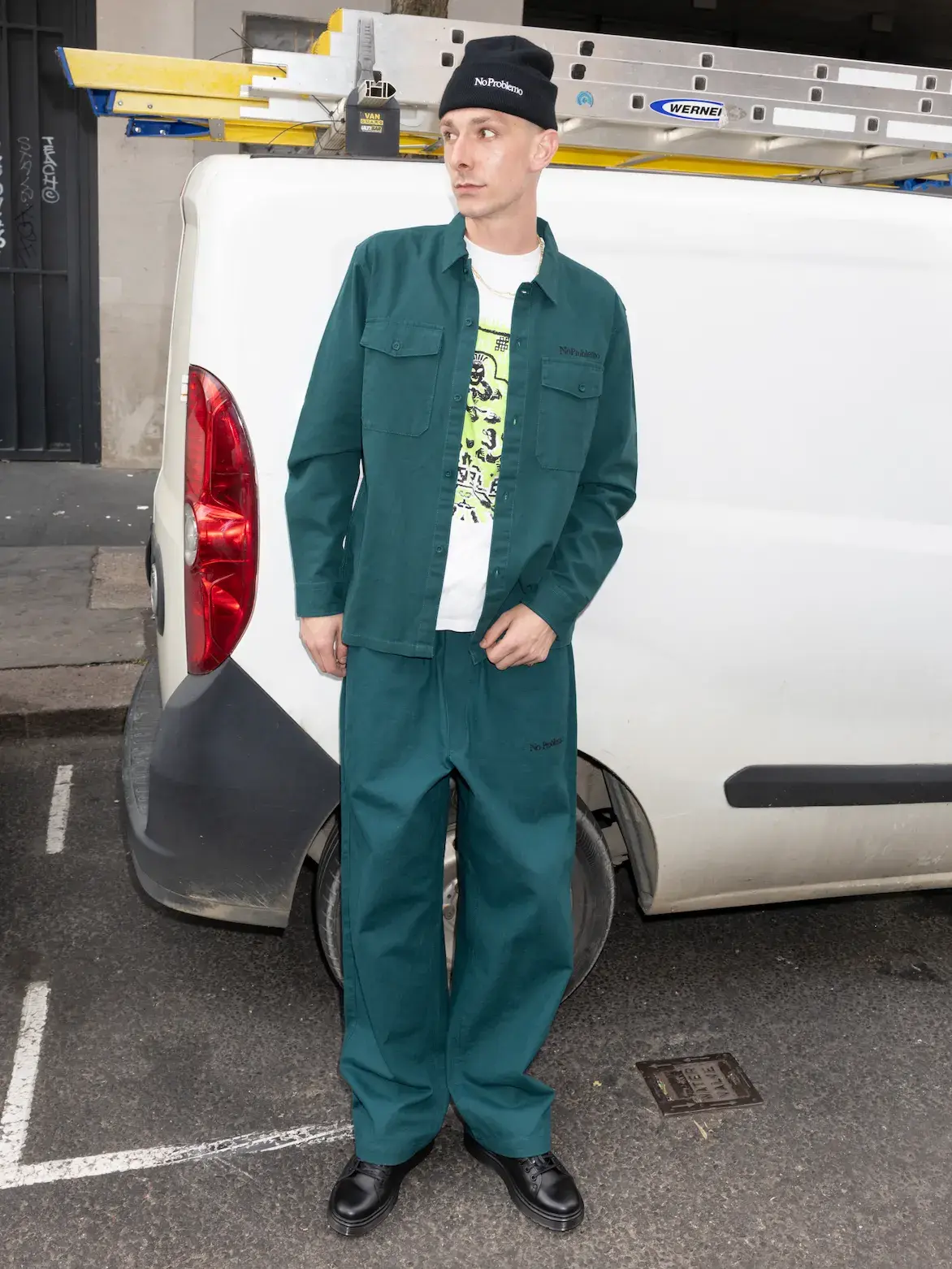 NO PROBLEMO AW26 COLLECTION DETAILS image of Two models wear No Problemo AW26 clothing. One wears a camouflage fleece and cap. The second person wears a blue striped long-sleeve polo shirt. (image 5 of 8)