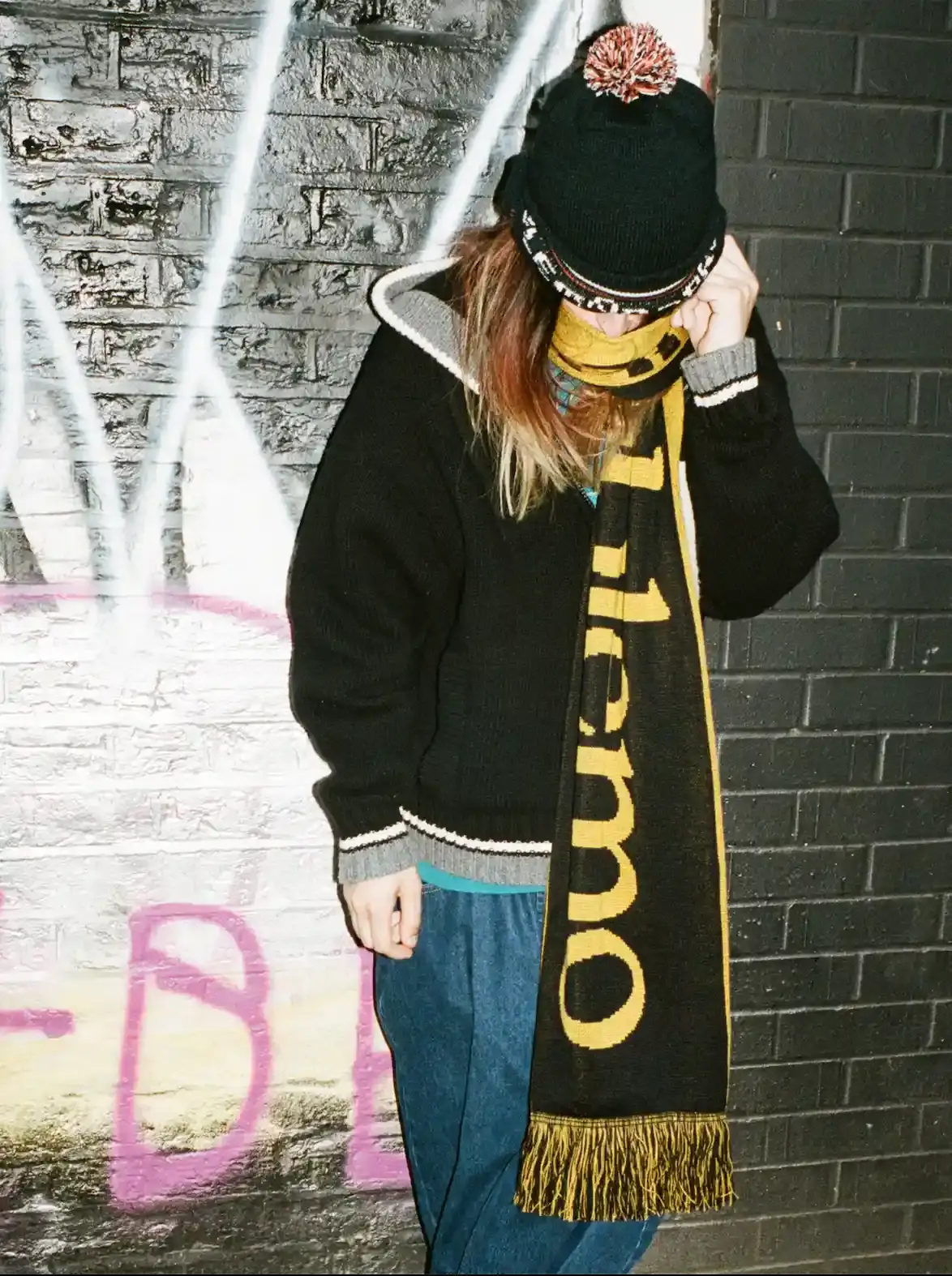 NO PROBLEMO AW26 COLLECTION DETAILS image of Two models wear No Problemo AW26 clothing. One wears a camouflage fleece and cap. The second person wears a blue striped long-sleeve polo shirt. (image 7 of 8)