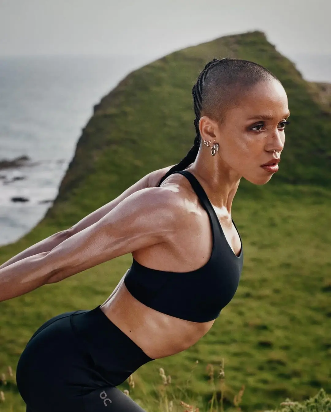 FKA twigs engaging in a holistic training session, highlighting the connection between mind and body. The image, part of On’s ‘The Body is Art’ campaign, evokes a sense of inner beauty and meditative well-being (image 3 of 4)