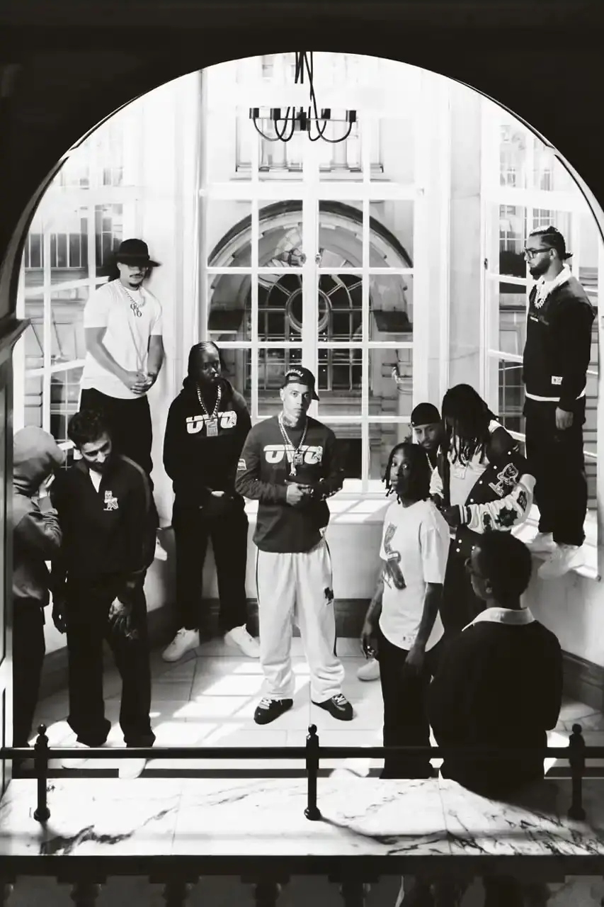 OVO PARTNERS WITH CHELSEA FC FOR LIMITED COLLECTION image about October's Very Own and Chelsea Football Club launching a collaborative clothing line. British rapper Central Cee models the collection which includes a varsity jacket, various shirts, hoodie and cap. The partnership combines Toronto streetwear culture with London football heritage through items featuring a merged OVO-Chelsea logo design. (image 5 of 6)