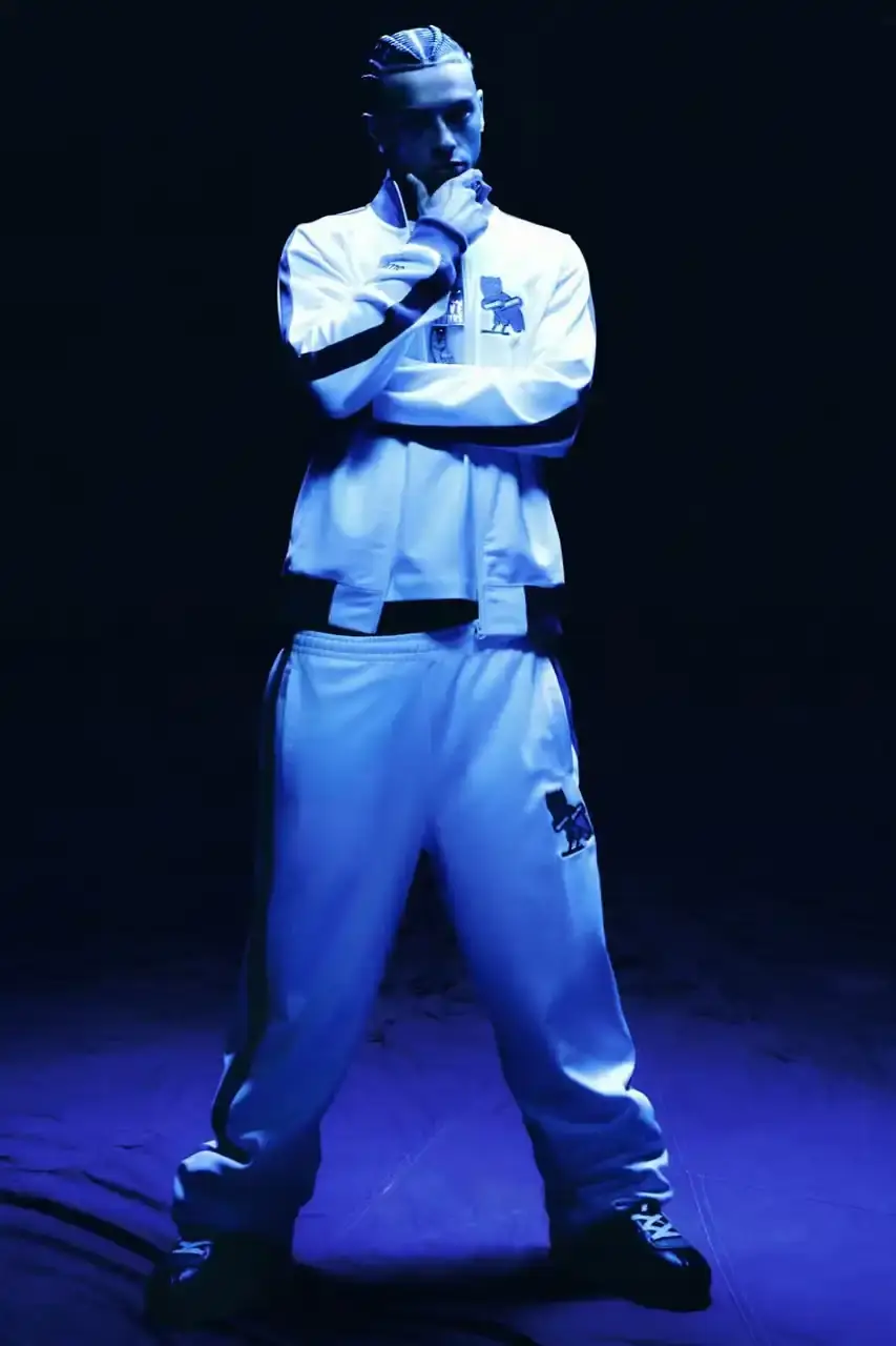 OVO PARTNERS WITH CHELSEA FC FOR LIMITED COLLECTION image about October's Very Own and Chelsea Football Club launching a collaborative clothing line. British rapper Central Cee models the collection which includes a varsity jacket, various shirts, hoodie and cap. The partnership combines Toronto streetwear culture with London football heritage through items featuring a merged OVO-Chelsea logo design. (image 2 of 6)
