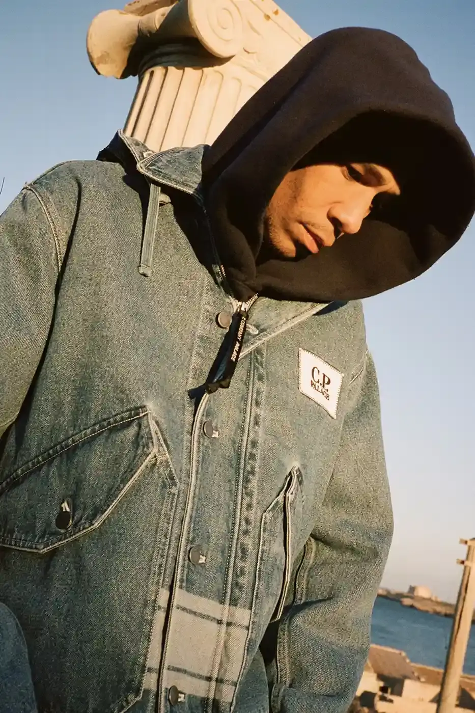 PALACE MEETS C.P. COMPANY: SKATE STYLE FUSES WITH ITALIAN CRAFT A fashion collaboration between Palace and C.P. Company. It details the "C.P. Palace" capsule collection featuring the Goggle Jacket, denim pieces, and various apparel in blue and khaki colors. The article provides information about the collection's availability starting March 28 at C.P. Company and Palace stores in multiple cities, plus a special pop-up at Dover Street Market Paris from March 28-30. (image 7 of 21)