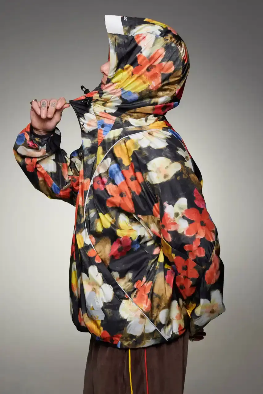 Palace Skateboards/Theo Sion Palace Spring 2025 lookbook showcasing a diverse collection of streetwear. Various models wear pieces including a tiger-embroidered varsity jacket, GORE-TEX outerwear, camouflage patterns, and racing-inspired jerseys. The collection features a mix of athletic and casual styles in multiple colorways, with detailed shots of snake graphics and workwear pieces (image 20 of 20)