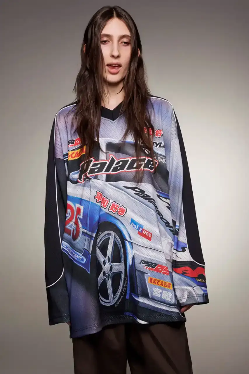Palace Skateboards/Theo Sion Palace Spring 2025 lookbook showcasing a diverse collection of streetwear. Various models wear pieces including a tiger-embroidered varsity jacket, GORE-TEX outerwear, camouflage patterns, and racing-inspired jerseys. The collection features a mix of athletic and casual styles in multiple colorways, with detailed shots of snake graphics and workwear pieces (image 14 of 20)