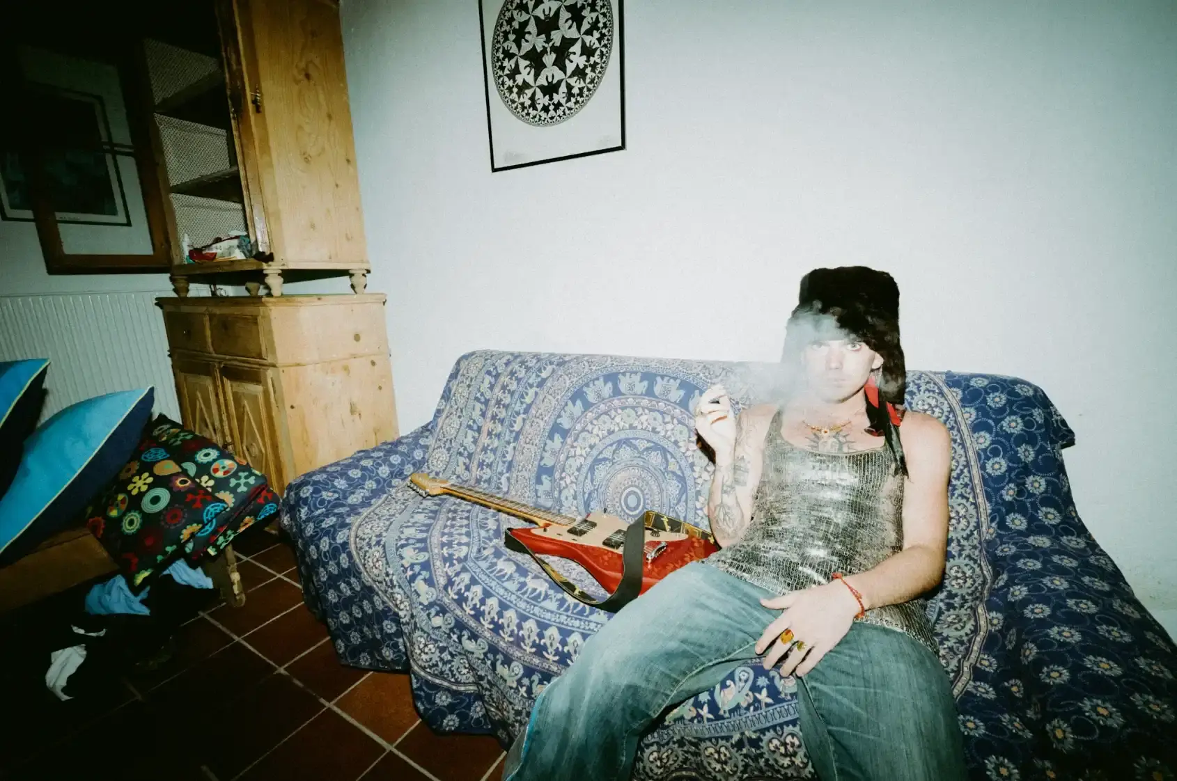 Piccolo, founding member of bnkr44, discusses his solo debut Stellar Boy. The project combines a graphic novel with an indie rock album. Both explore themes of silence, identity, and emotional expression. The album features 13 tracks across lo-fi, bedroom rock, and post-grunge styles. A recurring character wears a star-shaped mask, symbolizing protection and communication. Piccolo drew inspiration from childhood, family, and his need for creative release after years in a collective. The project creates a parallel universe for listeners seeking escape.