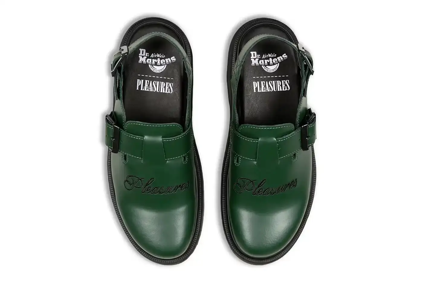 Ian Dooley/Pleasures Green leather Dr. Martens Jorge Mule featuring black metal buckles, cursive PLEASURES branding stitched on the upper, signature yellow stitching, and a black Vibram outsole. The collaboration merges both brands' distinctive styles in a versatile slip-on design. (image 5 of 11)