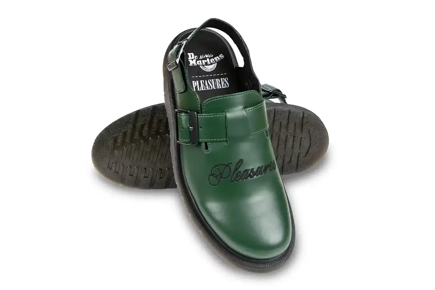 Ian Dooley/Pleasures Green leather Dr. Martens Jorge Mule featuring black metal buckles, cursive PLEASURES branding stitched on the upper, signature yellow stitching, and a black Vibram outsole. The collaboration merges both brands' distinctive styles in a versatile slip-on design. (image 7 of 11)