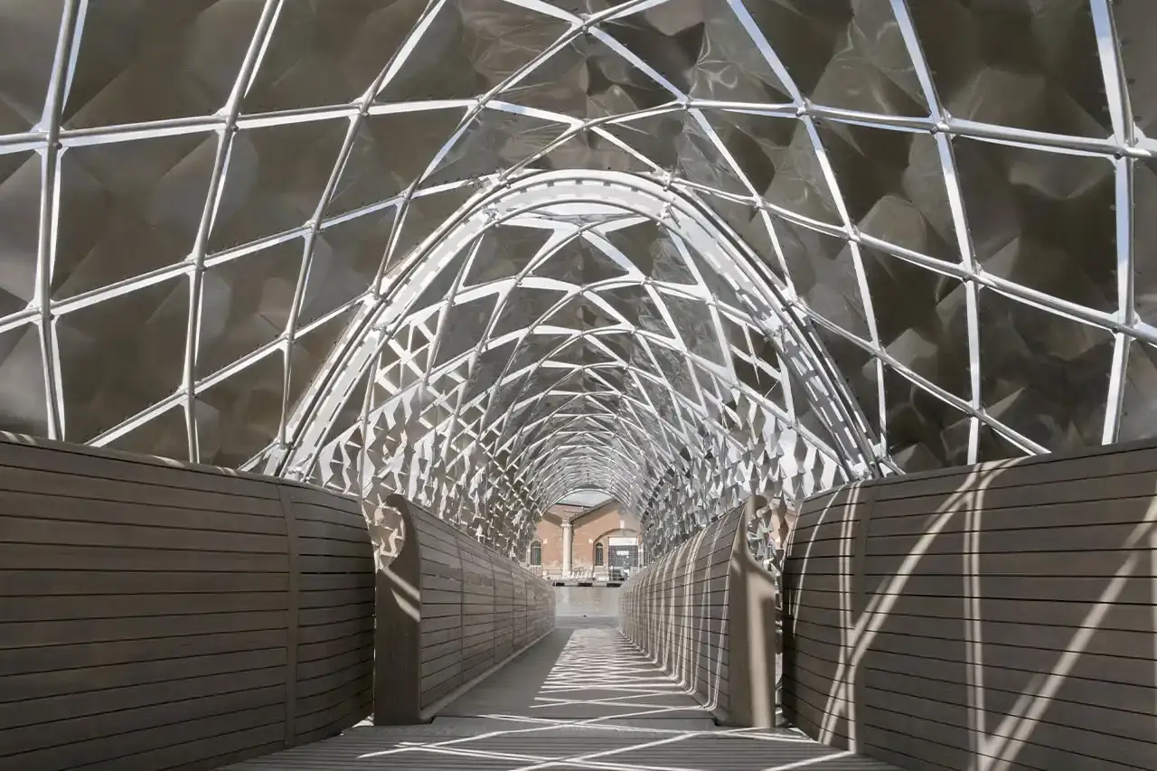 FOSTER AND PORSCHE PRESENT VENICE TRANSPORT HUB image about architectural partnership between Porsche and Norman Foster Foundation presenting electric mobility concepts at Venice Biennale. Content includes details about a 120-foot installation featuring sustainable transportation solutions like electric boats and water bikes, exhibition locations, and future collaboration plans. Text is structured with clear headings, bullet point summary, and descriptive paragraphs suitable for screen readers. (image 4 of 8)