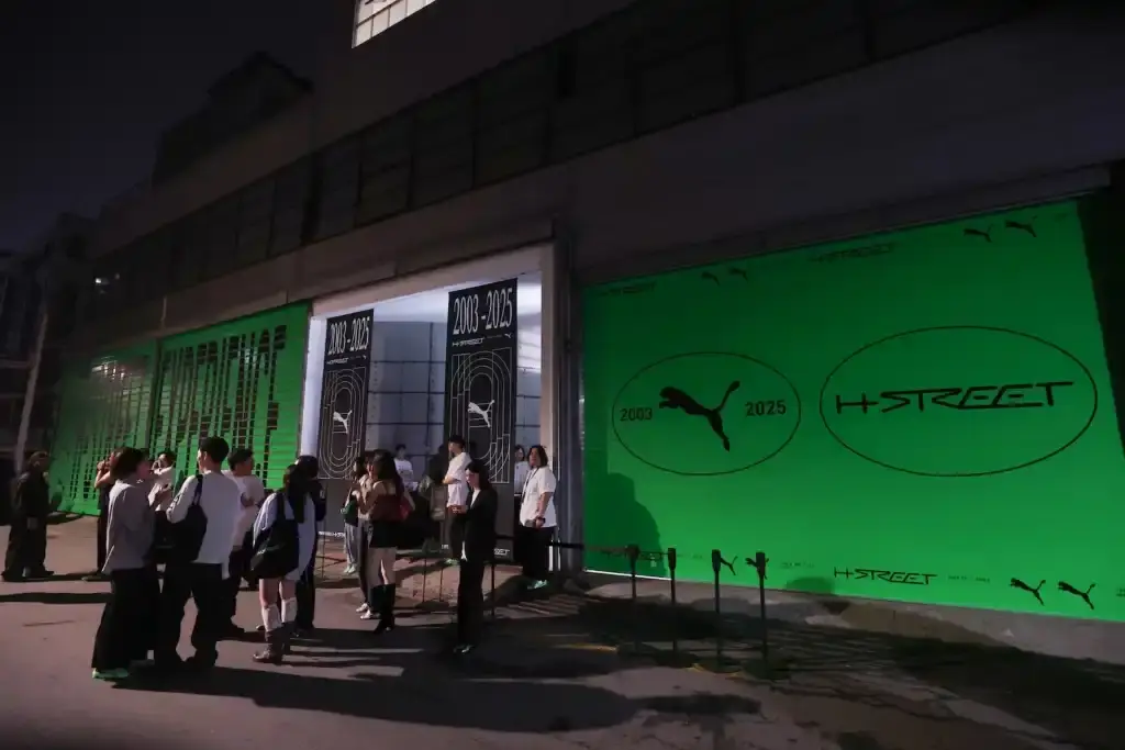 PUMA'S H-STREET SNEAKERS LAUNCH CELEBRATED WITH SEOUL EXHIBITION image of PUMA's H-Street sneakers launch event in Seoul, describing the exhibition venue's athletics-inspired design, notable attendees including K-pop celebrity Rosé, and quotes from PUMA's Global Marketing Director. The piece explains that the exhibition is part of PUMA's Future Archives initiative honoring classic designs and mentions that it remains open to the public through May 18 with various interactive elements including styling areas, music spaces, archival displays, and group activities.