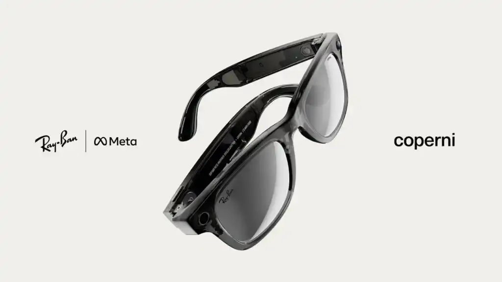 Limited edition Ray-Ban Meta x Coperni smart glasses featuring transparent black frames with gray mirrored lenses. The Wayfarer-style sunglasses include built-in AI capabilities, camera, and audio features, presented in a special charging case with Limited Edition numbering visible on the inner temple. (image 2 of 2)