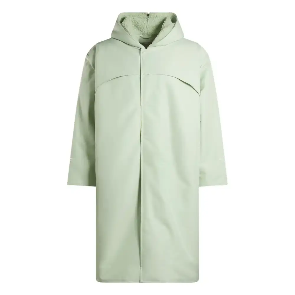 Reebok Tobe Nwigwe wearing a mint green coach jacket and black pants from the Reebok x Chukwu collection, standing next to the Chukwu OTU sneaker (image 1 of 9)