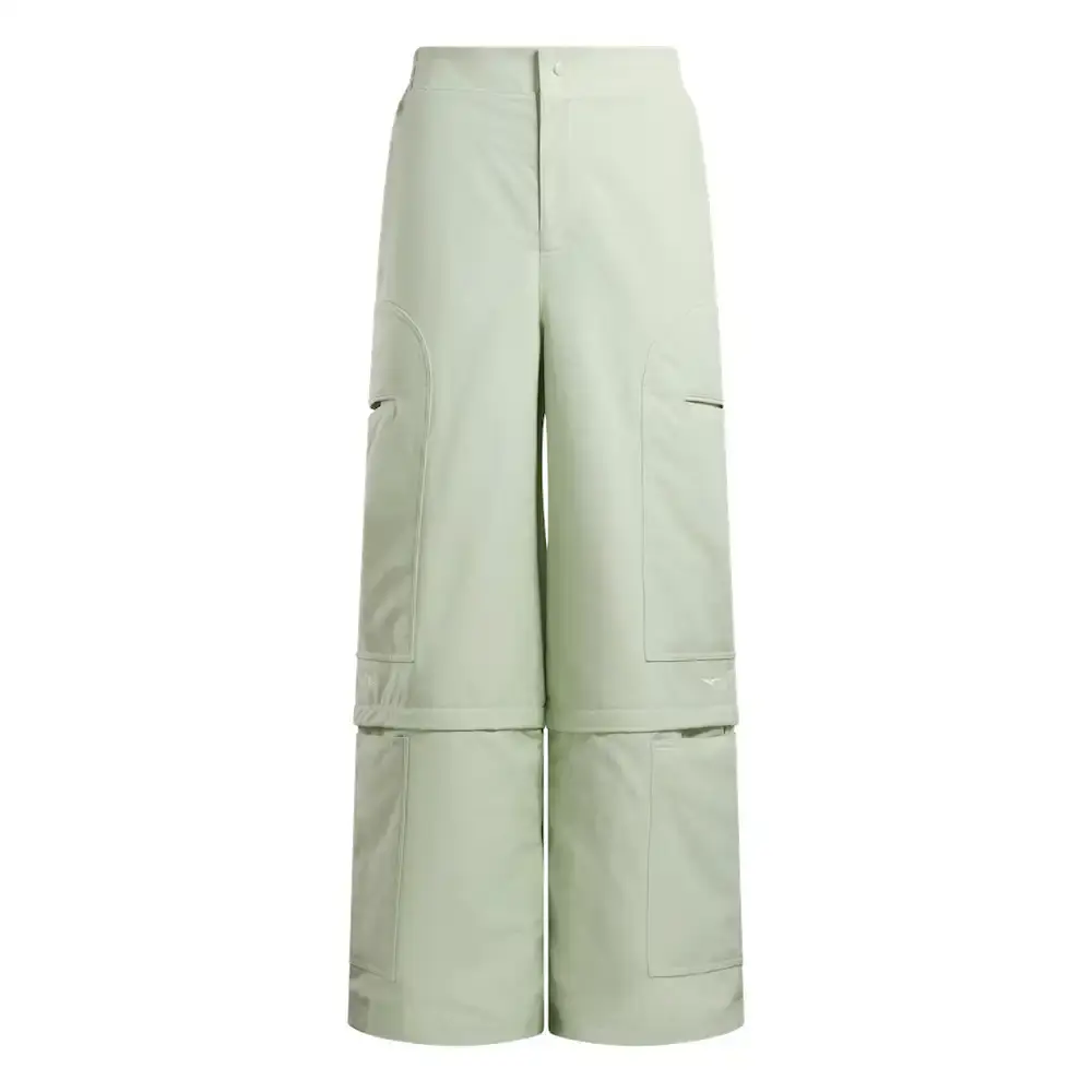 Reebok Tobe Nwigwe wearing a mint green coach jacket and black pants from the Reebok x Chukwu collection, standing next to the Chukwu OTU sneaker (image 2 of 9)