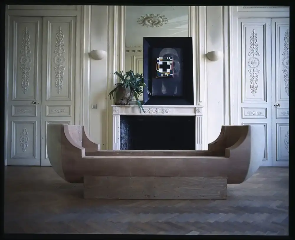 Assaf Shoshan/PIN–UP Interior of Rick Owens' brutalist Parisian home featuring unpolished floors, exposed wiring, a platform bed with Swiss Army blankets, and minimalist furnishings. (image 3 of 6)