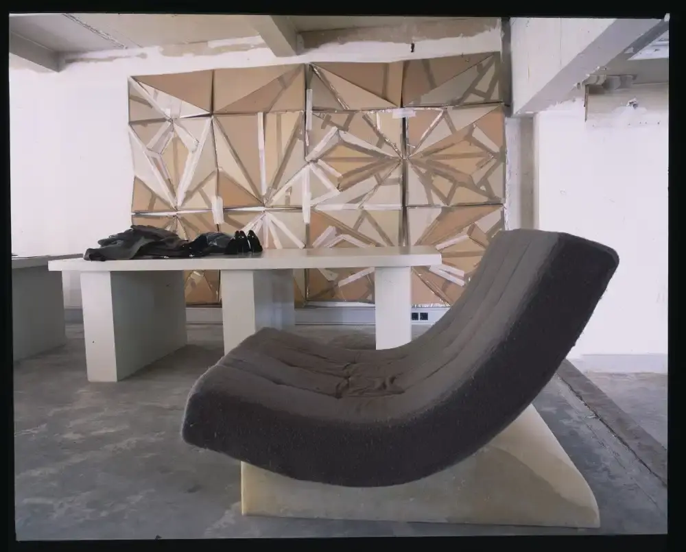 Assaf Shoshan/PIN–UP Interior of Rick Owens' brutalist Parisian home featuring unpolished floors, exposed wiring, a platform bed with Swiss Army blankets, and minimalist furnishings.