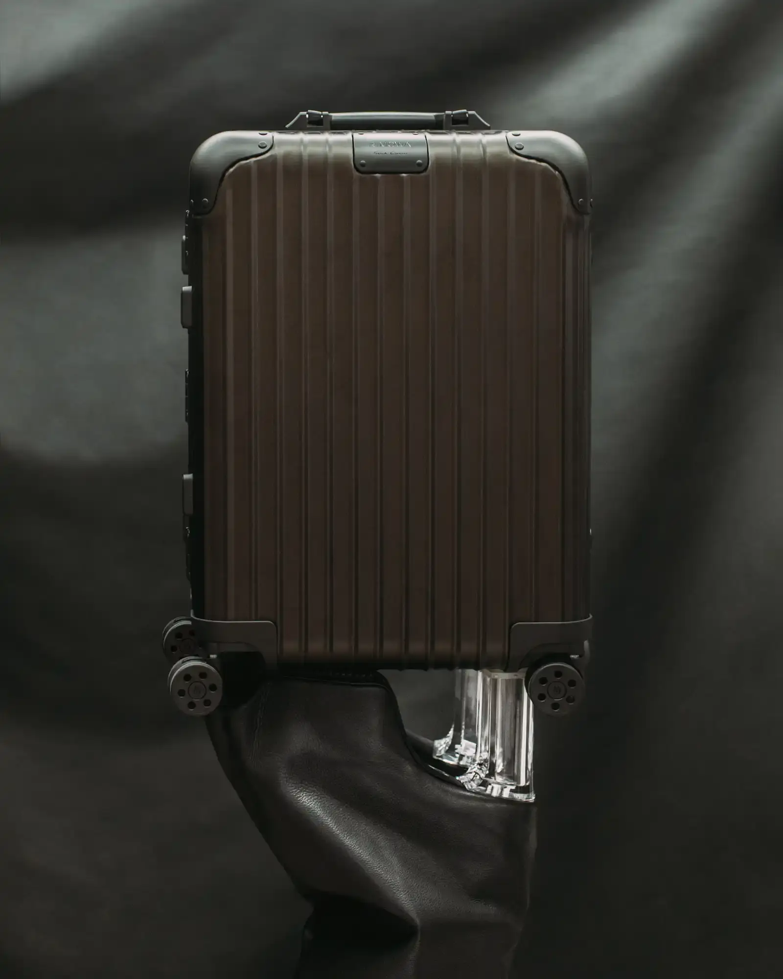 RIMOWA RIMOWA x Rick Owens bronze aluminum cabin suitcase with dark metallic finish and black leather details against neutral background (image 2 of 4)