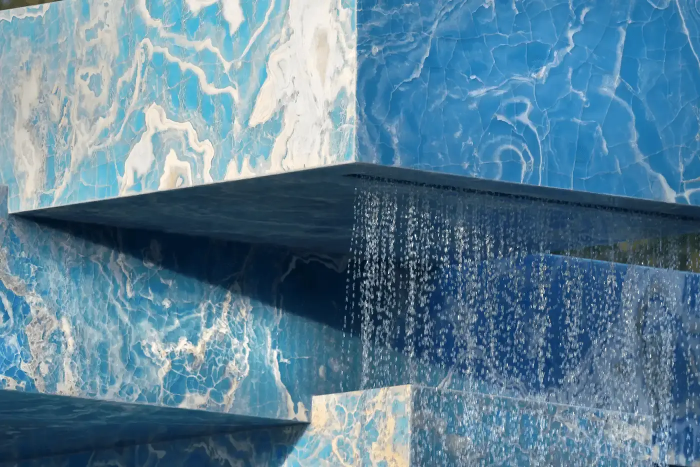 SABINE MARCELIS' ONYX FOUNTAIN TRANSFORMS VONDELPARK IN AMSTERDAM Vondel Fountain, Stacked: A large, striking fountain made of stacked, recycled onyx slabs located in one of the lakes in Amsterdam's Vondelpark. Water cascades from two sides, creating a soothing, relaxing sound (image 3 of 7)