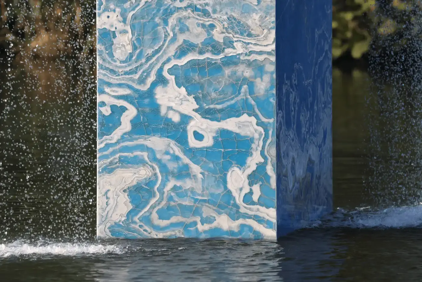 SABINE MARCELIS' ONYX FOUNTAIN TRANSFORMS VONDELPARK IN AMSTERDAM Vondel Fountain, Stacked: A large, striking fountain made of stacked, recycled onyx slabs located in one of the lakes in Amsterdam's Vondelpark. Water cascades from two sides, creating a soothing, relaxing sound (image 4 of 7)