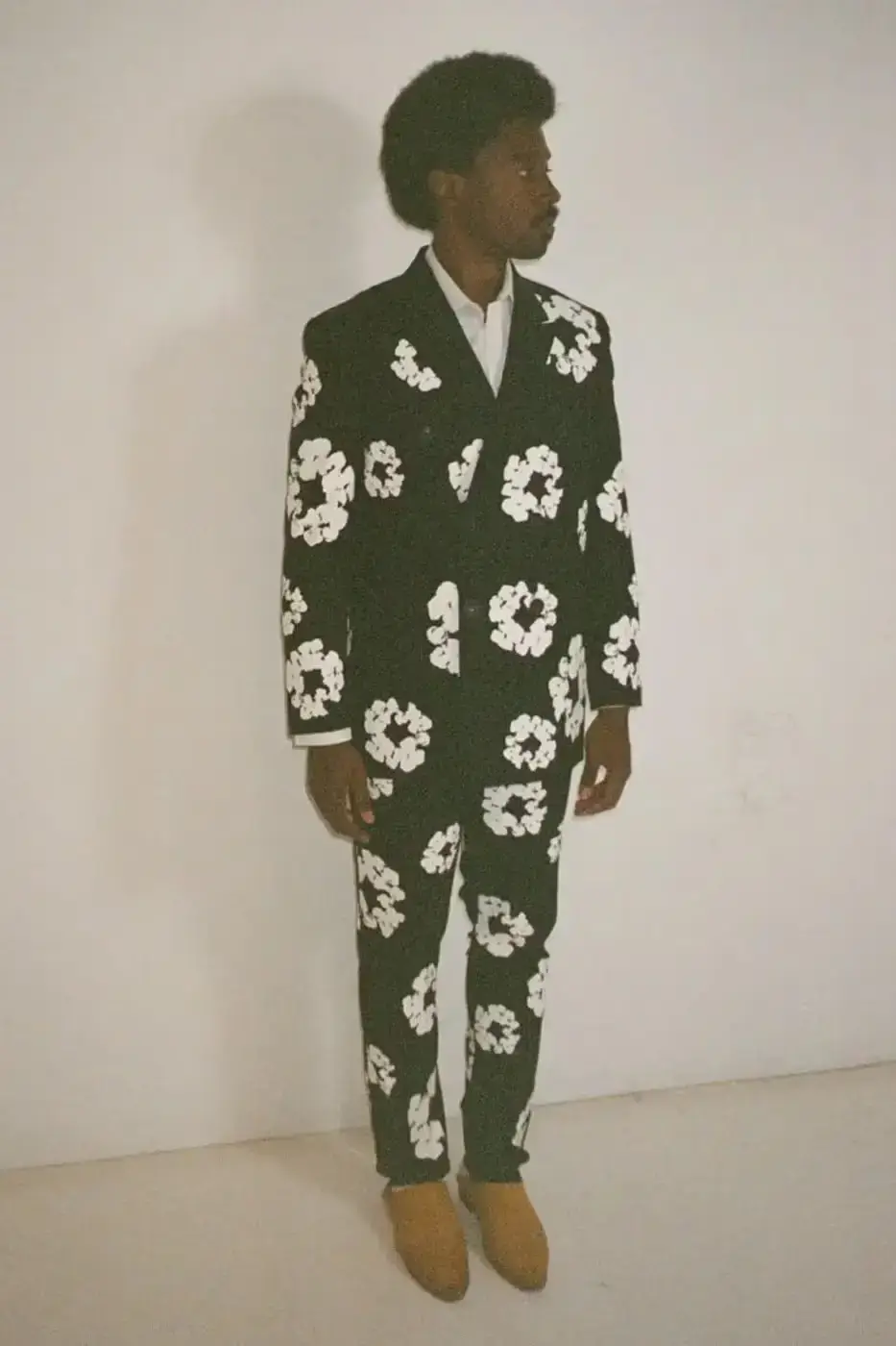 SAINT Mxxxxxx SAINT Mxxxxxx and Denim Tears collaborative Fall/Winter 2024 collection, displaying a tailored double-breasted blazer with wreath print, matching slacks, and a necktie