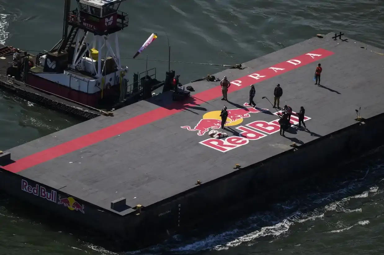 SKYSURFER MAKES HISTORY ON BAY BRIDGE WEARING PRADA image of Professional skysurfer Sean MacCormac performs historic stunt gliding across San Francisco Bay Bridge cables after helicopter jump, supported by Prada Linea Rossa and Red Bull partnership. (image 3 of 3)